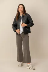 Campera de cuero negro estilo capitoneada, con diseño acolchado de rombos, cuello camisero, cierre frontal con botones a presión y bolsillos laterales.