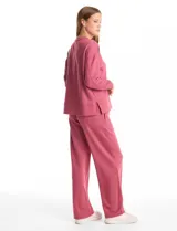 Buzo deportivo de cuello redondo, con hombros caídos y mangas largas con puños. Presenta costuras decorativas tipo pespunte en la parte frontal y en las mangas, con un diseño de ruedo recto y tajos laterales.