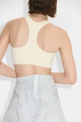Top deportivo color beige con espalda nadadora, escote redondo y banda elástica inferior.