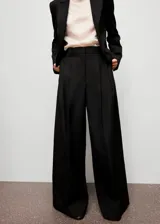 Pantalón wide leg de tiro alto color negro, con diseño largo, bolsillos laterales, detalle de pinzas y cierre oculto con botón, gancho y cremallera.