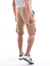 Bermuda tipo cargo color beige, con bolsillos laterales con cierre y bolsillos cargo en las piernas. Presenta cierre frontal con botón y presillas para cinturón.