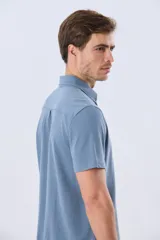 Camisa de piqué lisa color celeste, de manga corta, con cuello camisero y cierre frontal de botones oscuros.