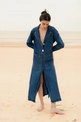 Tapado largo de jean con dos amplios tajos laterales que le dan movimiento y estilo. Cuenta con dos grandes bolsillos delanteros y un botón de guampa, distintivo de la marca.