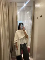 Ruana abierta de tejido liviano con caída fluida y textura sutil, diseñada con un corte amplio y versátil que envuelve el cuerpo.