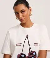 Remera de algodón color blanco, de corte recto, con cuello redondo y mangas cortas. Estampa frontal con cerezas y texto "Summer Flavours".