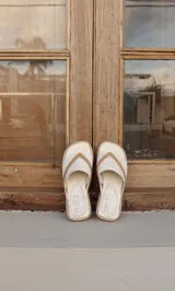 Sandalias de cuero color beige con estampado craquelado y tiras cruzadas color marrón.