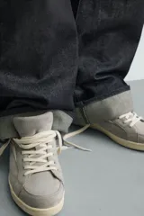 Zapatilla de estilo retro confeccionada en una combinación de piezas de gamuza y cuero sintético en tonos gris y crema, con suela de goma a contraste.