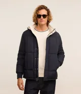 Campera puffer de hombre reversible, con diseño acolchado, cuello alto, capucha y cierre frontal.