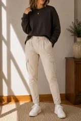Pantalón cargo color beige de corte ajustado, con bolsillos laterales en los muslos, trabillas para cinto y pinzas en la cintura.
