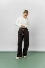 Pantalón de corte relajado y pierna recta, confeccionado en tejido tipo corderoy liviano. Presenta cintura elastizada con cordón ajustable y diseño de silueta amplia.