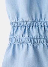 Top de denim suave color celeste con cuello halter, escote en V profundo y cordón ajustable en la cintura.