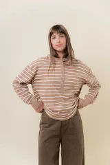 Buzo liviano de calce holgado con diseño a rayas horizontales en color beige y blanco. Presenta cuello mao con cartera frontal de botones y mangas largas con puños anchos.