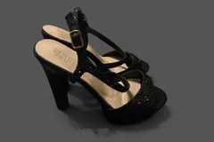 Sandalias de fiesta color negro con plataforma y taco alto cuadrado. Presentan tiras cruzadas en el empeine con acabado brillante y cierre de pulsera con hebilla metálica.