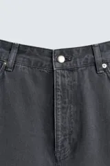 Pantalón wide fit color gris oscuro, confeccionado en tejido ligero de algodón. Cuenta con cinco bolsillos y efecto lavado. Cierre frontal con cremallera y botón.