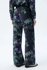 Pantalón palazzo de tencel color negro con estampado de diseño orgánico, tiro alto y pierna ancha.