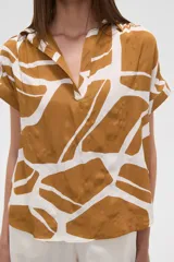 Blusa holgada de manga corta, con escote en V y estampado abstracto en tonos verde oliva y blanco.