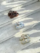 Sandalias de plataforma doradas, con suela ancha y tiras anchas cruzadas en el empeine y una tira ajustable en el tobillo.