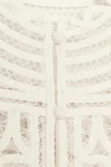 Blusa sin mangas confeccionada en tejido tipo crochet con diseño geométrico calado, cuello redondo y cierre frontal con botones.