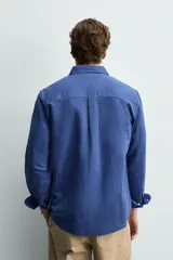 Camisa regular fit celeste confeccionada en mezcla de lino y algodón, con cuello abotonado, manga larga, bolsillo frontal en el pecho y cierre de botonadura.