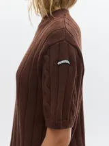 Buzo tejido de manga corta color rojo, con cuello redondo y diseño de punto acanalado y trenzado.