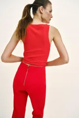 Pantalón de tiro alto en color negro, con diseño de corte recto y ligeramente acampanado. Presenta costuras verticales marcadas en el frente y bolsillos laterales de vivo.