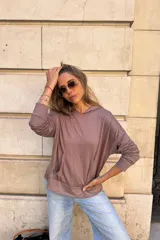 Canguro con capucha de manga larga, color marrón topo, de calce amplio y tejido suave. Presenta bolsillo canguro frontal y puños y ruedo ajustados.