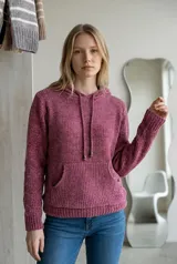 Sweater tipo canguro de tejido chenille, con capucha y cordones ajustables. Presenta un bolsillo frontal tipo canguro, mangas largas y puños y ruedo acanalados.