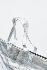 Bolso tipo tote bag color dorado con efecto arrugado y dos asas superiores.