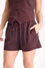 Short de lino color bordó con cintura elástica, cordón ajustable y bolsillos laterales.