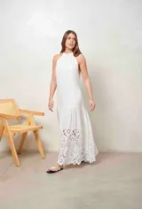 Vestido largo beige con cuello halter y detalle de broderie calado en el dobladillo inferior.
