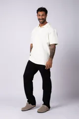 Chomba de manga corta con cuello polo, confeccionada en tejido de punto acanalado de textura pesada. Presenta un calce relajado y cuenta con una pequeña etiqueta distintiva en el ruedo.