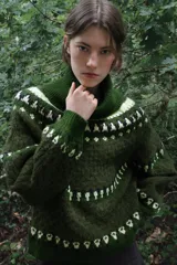 Jersey de punto con cuello subido y manga larga, diseño de jacquard con motivos geométricos en tonos verdes y crema.