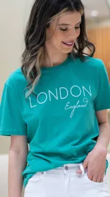 Remera verde con estampado frontal de la palabra "London" en letras blancas y la palabra "England" en cursiva debajo.