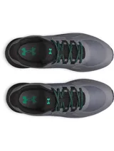 Championes de trail running Under Armour Charged Bandit TR 3, color gris con detalles en negro y verde. Presentan una parte superior de malla técnica para mayor ventilación, refuerzos estratégicos para durabilidad y entresuela Charged Cushioning para máxima amortiguación y respuesta. La suela exterior cuenta con tacos técnicos diseñados para ofrecer una tracción superior en terrenos irregulares.