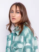 Sobrecamisa a cuadros grandes color lila, rosa y blanco, con cuello camisero, cierre frontal con botones metálicos a presión, dos bolsillos de parche en el pecho y corte recto.