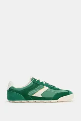 Zapatillas de estilo running con diseño en color verde y detalles en blanco y amarillo, confeccionadas con una combinación de materiales textiles y sintéticos, cierre de cordones y suela plana.