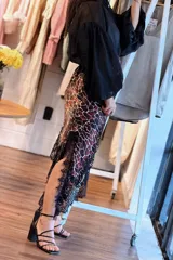 Falda asimétrica de seda con estampado animal print, talle elástico y detalle de encaje negro en el ruedo.