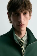 Sudadera de algodón azul con cuello alto y cierre frontal de cremallera de un cuarto. Presenta un corte regular y puños y bajo en rib.