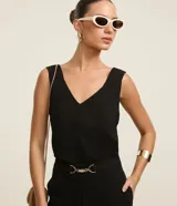 Blusa sin mangas de tejido airflow, con escote en V y breteles anchos. Presenta un diseño minimalista con detalle de pespunte vertical en el frente.