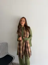 Bufanda de tejido suave con diseño de cuadros grandes en tonos negro y beige, terminada con flecos en los extremos.