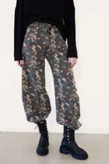 Borcego de caña corta confeccionado en cuero negro, con diseño de cordones y ganchos metálicos, cierre lateral y suela de plataforma dentada.