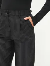 Pantalón negro de vestir con finas rayas verticales blancas, corte recto y tiro alto.