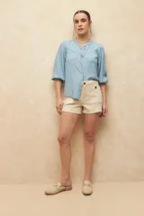 Short de jean de tiro alto color azul, con cuatro bolsillos frontales con botón.