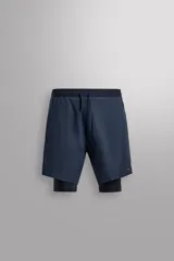 Shorts de entrenamiento azul marino con calza interior negra. Cintura elástica ajustable con cordón, bolsillos laterales con cierre y aberturas laterales en el bajo.