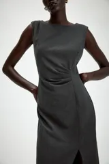 Vestido midi sin mangas de cuello redondo, con detalle de drapeado en el delantero y abertura frontal en el bajo. Cierre posterior con cremallera oculta.