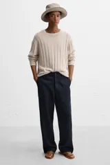 Sandalia minimalista de cuero negro, con tira delgada en el empeine y suela plana.