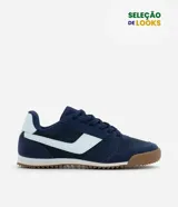 Championes de estilo vintage runner color azul marino con detalles en blanco y suela de goma color caramelo. Presentan cierre por cordones y diseño con recortes laterales.