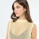Top sin mangas de tejido de punto tipo crochet, color amarillo pastel, con cuello redondo y diseño calado.