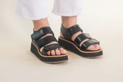 Sandalias negras de cuero con plataforma y tiras con ajuste de velcro.