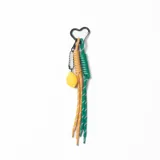 Llavero con mosquetón en forma de corazón, compuesto por dos cordones de tela trenzada en colores amarillo y verde, y un dije colgante en forma de limón.
